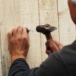 Man,Fixing,Wooden,Plank,With,A,Nail